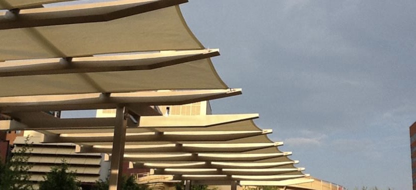 A waterproof shade sail cover on top of a pergola structure